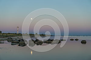 Skew lighthouse in the Baltic Sea. Shore, evening light, sunset, moon and architecture concept.