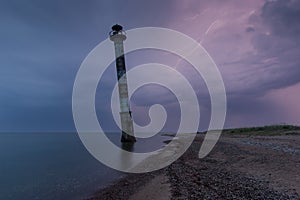 Skew lighthouse in the Baltic Sea. Stormy night and lightning. Kiipsaar, Harilaid, Saaremaa, Estonia