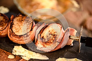 Skewer of grilled scallops wrapped in ham