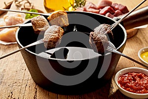 Skewered meat chunks and pot of sauce