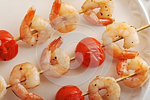 Skewered shrimp with cherry tomatoes on wooden stick