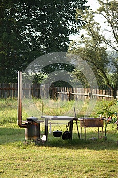 Skewers and grill on the grill. Barbecue and stove for outdoor cooking. Old wooden fence, rural recreation