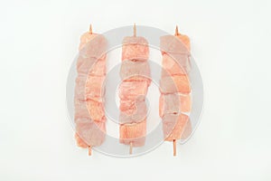 Skewers from raw chicken meat fillet on a white plate for supermarket on white background.Food for retail.Chicken