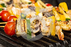 Skewers of seafood grilling