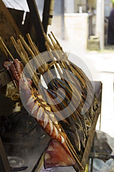 Skewers of squid and fish cooked over an open fire, a delicious and affordable meal enjoyed by locals and tourists alike