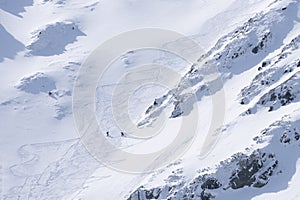 Ski alpinists in snowy alpine terrain climbing uphill , Slovakia, Europe
