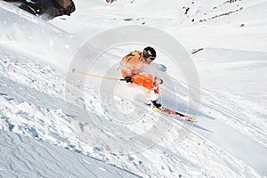 Ski athlete in a fresh snow powder rushes down the snow slope