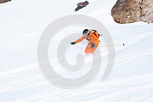 Ski athlete in a fresh snow powder rushes down the snow slope
