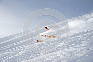 Ski athlete in a fresh snow powder rushes down the snow slope