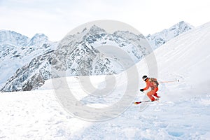 Ski athlete in a fresh snow powder rushes down the snow slope