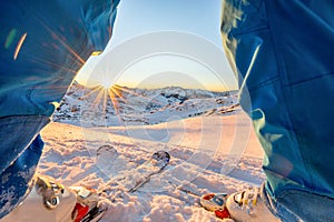 Ski athlete standing in front of wonderful sunset  on top of the mountain - Legs view of young skier with sun back light - Sport