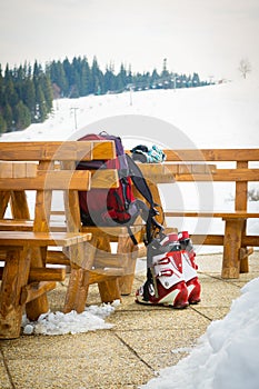 Ski boots, gloves and a backpack in an outdoor bar in a ski resort