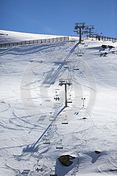 Ski chair lift with skiers. Ski resort in Sierra Nevada