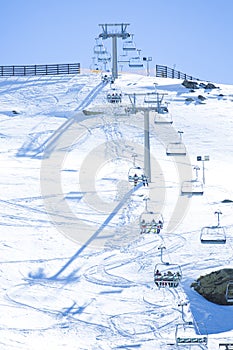 Ski chair lift with skiers. Ski resort in Sierra Nevada