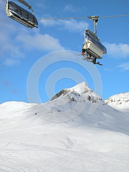 Ski chair-lift with skiers. Switzerland.