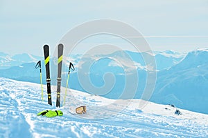 Ski equipment in the snow. Ski slope and mountain peaks is in the background