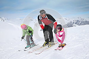 Ski instructor teaching children skiing