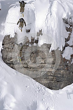 Ski jump from a cliff in deep powder