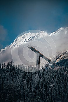 Ski jump in winter nature. Big white snowy mountains in background