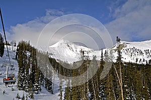 Ski Lift Carries Skiers to Mountain Peak