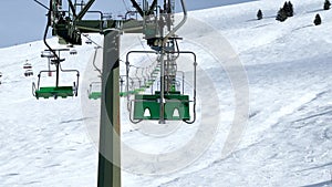 Ski lift chairs move on the rope way at alpine winter resort