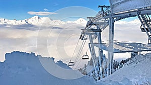 ski lift covered with frost above a sea of clouds in a ski resort