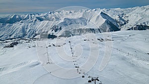 Ski lift empty ropeway on hilghland alpine mountain winter resort on bright sunny day.