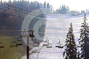 Ski lift with empty seats over the snow mountain in ski resort