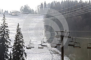 Ski lift with empty seats over the snow mountain in ski resort