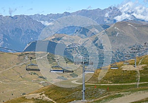 Ski lift near winter and summer sport station Les deux Alpes and view on Alpine mountains peaks in summer, Isere, France