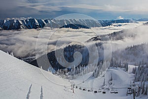 Ski Lift Riding Up Through Clouds at Resort