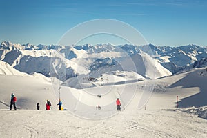 Ski lift ropeway station on hilghland alpine peak at mountain winter resort on bright sunny day. chairlift cable with