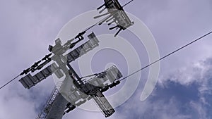 Ski lift on ski resort. Skiers climb on a ski chair elevator up to ski slope with falling snow