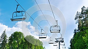 Ski lift in the summer. Chair lift with empty cabins on a sunny summer day against the blue sky