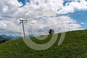 Ski lift in a summertime meadow with a cable railway cabin next to it
