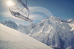 Ski-lift wire on the background of the snow-white Mountains of the Caucasus, Dombai on a winter sunny day. Toned image