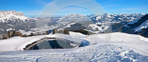 Ski piste with accumulation lake and view to Wilder Kaiser mountains