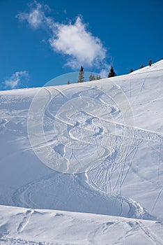 Ski piste with deep powder snow and tracks from skiing or snowboard