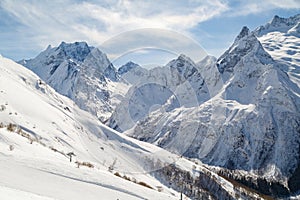 Ski piste, a small chair ski-lift against the backdrop of the Caucasus Mountains range near the town of Dombai, Russia
