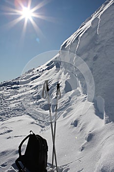 Ski poles and rucksack on snow