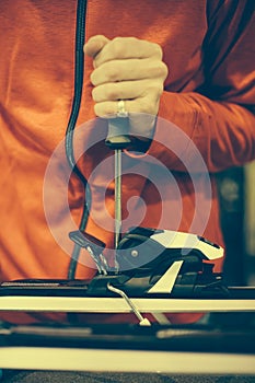 Ski repair shop worker adjust the bindings