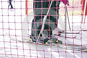 Ski resort, children and adults on skis in line for the uphill ski lift