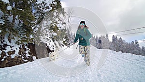 Ski resort entertainments. Friends have fun on the ski resort. Young girl with blonde hair caress Siberian husky