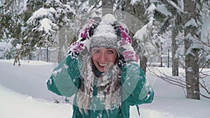 Ski resort entertainments. Happy young woman playing with snow