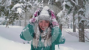 Ski resort entertainments. Happy young woman playing with snow