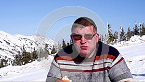 Ski resort man eats Picnic at the ski resort in winter in Sunny weather close-up