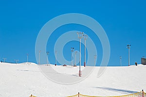 Ski resort, snow slope, trail with towers and floodlights