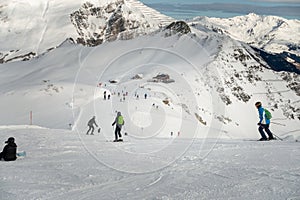 Ski resort in winter Alps. Skiers ride down the slope