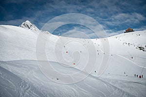 Ski resort in winter Alps. Skiers ride down the slope. Tux, Hintertux, Austria