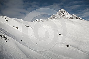 Ski resort in winter Alps. Skiers ride down the slope. Tux, Hintertux, Austria